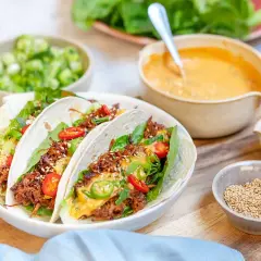 Tacos med koreansk pulled pork, toppade med sallad, chili och sesamfrön. Serveras med en krämig sås och färska grönsaker.
