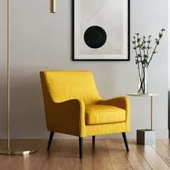 Ett gult vardagsrum med en bekväm fåtölj, en golvlampa och en vas med blommor. En modern tavla hänger på väggen.