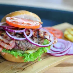 Pyszny burger z bekonem, sałatą, pomidorem i cebulą. Idealny przykład, jak składac burgera, by był soczysty i pełen smaku.