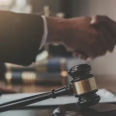 Sądowy młotek i uścisk dłoni symbolizują zakończenie sprawy. Libor co to? To może być początek nowego rozdziału.