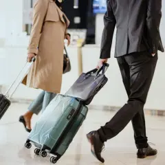 Biznesmeni z walizkami spieszą się, by zdążyć na samolot. Ciekawe, ile czasu na wypłatę delegacji mają po powrocie.
