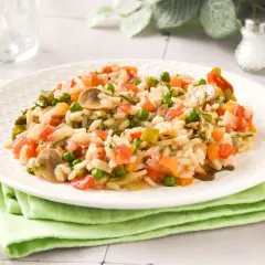 Un cremoso risotto de verduras con guisantes, champiñones y tomate.