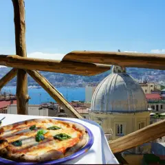 Smakowita pizza i kawa na tarasie z widokiem na Neapol. Ceny we Włoszech mogą być różne, ale takie widoki są bezcenne.