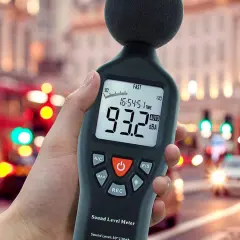 Mano sosteniendo un medidor de sonido para medir db en una calle ruidosa de la ciudad.