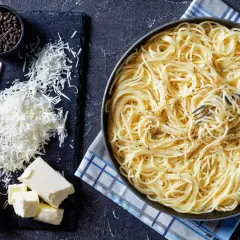 Spaghetti conditi con burro e pepe, pronti per essere arricchiti con pecorino, fonte di proteine.