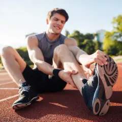 Zawodnik na bieżni wykonuje ćwiczenia rozciągające, co jest kluczowe w rehabilitacji w sporcie po kontuzji.