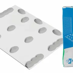 Worek kleju gipsowego Rigips obok płyty gipsowo-kartonowej z nałożonym klejem.