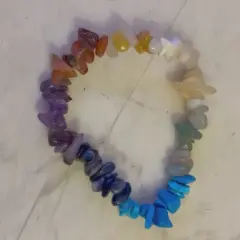 Ett färgglatt chakraarmband med stenar i regnbågens färger, från rött till lila.