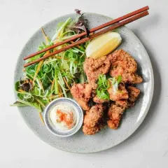 Chrupiący kurczak karaage z sałatką i dipem. Pałeczki czekają, by zacząć ucztę.