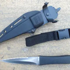 Daga táctica SOG con funda negra y correa de sujeción. Hoja de acero con sierra.