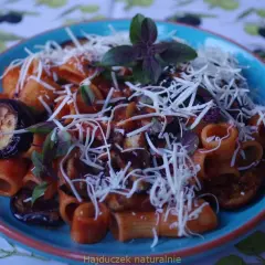 Pyszne danie pasta alla norma z makaronem rigatoni, bakłażanem w sosie pomidorowym i startym serem.