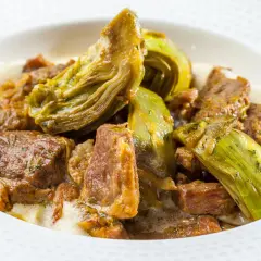 Un saporito agnello con carciofi in umido, un piatto tradizionale che profuma di casa.