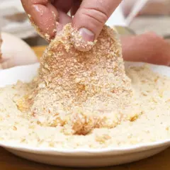 Fleisch wird in eine Schüssel mit **low carb panade** getaucht. Eierschalen liegen daneben.