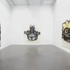 Gallery space with three expressive, cartoon-like portraits by Joyce Pensato.