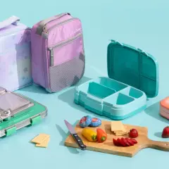 Colorful lunch bags and bento boxes, showcasing what is bento in Japanese: a compartmentalized meal for a balanced lunch.