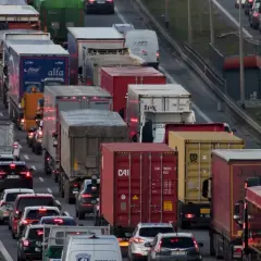 Korki na autostradzie w Polsce. Długi sznur samochodów i ciężarówek, widoczne znaki ostrzegawcze.