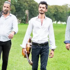Tre musicisti con contrabbasso e chitarre, pronti per un concerto di jazz manouche all'aperto.