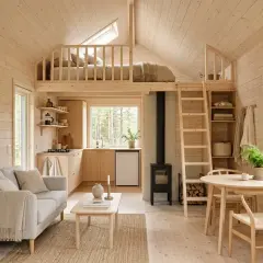 Mysig attefallshus inspiration med loftssäng, kök, soffa och kamin. Ljust trä och skandinavisk design.