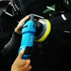 Detailing czarnego lakieru samochodu za pomocą polerki.