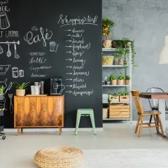 Kreative Ideen für einen kleinen Partyraum: Tafelwand mit Einkaufsliste und Café-Menü, Vintage-Schrank, Pflanzen und Essbereich.