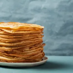 Stos puszystych naleśników proteinowych na talerzyku, idealnych na zdrowe śniadanie.