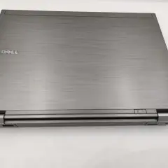 Zamknięty laptop Dell Latitude E6410, z widocznym logo Dell i przyciskami zasilania. Idealny do sprawdzenia dell latitude e6410 specyfikacja.