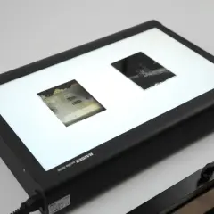 Jasne, oto opis:

Płaski skaner z podświetlaną powierzchnią, na której leżą dwa negatywy. Idealne narzędzie do digitalizacji dokumentów i starych fotografii.