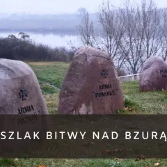 Kamienie pamięci z nazwami armii upamiętniają bitwę nad Bzurą. W tle rzeka i drzewa.