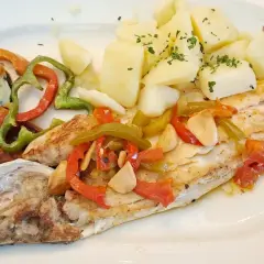 Lubina a la bilbaina con patatas y pimientos asados. Un plato delicioso y saludable.