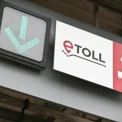 Znak e-TOLL z zielonymi strzałkami w dół i ikonami pojazdów.
