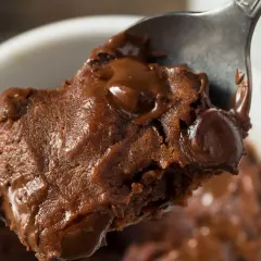 Łyżka z porcją pysznej, pieczonej owsianki brownie z roztopioną czekoladą.