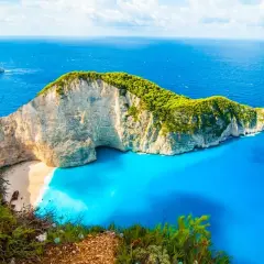 Widok na zatokę Navagio, słynną plażę w Grecji, z klifem porośniętym zielenią i turkusową wodą. Idealne miejsce na wakacje, jak z pocztówki z greckich miast.