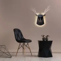 Lámpara pared negra con diseño de ciervo geométrico, ilumina la estancia con un toque moderno.