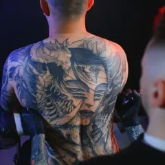 Męski tatuaż na barku z wieloma oczami i demoniczny motyw.