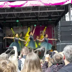 Ballettgruppe auf einer Bühne bei Veranstaltungen im Bergischen Land. Ein Publikum filmt die Darbietung.