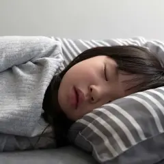 Ein kleines Mädchen schläft tief und fest. Wie lange machen Kinder Mittagsschlaf? Diese Frage beschäftigt viele Eltern.