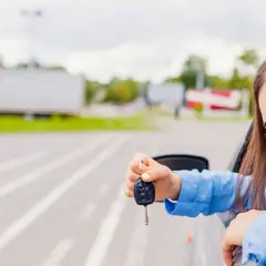 Ragazza sorridente con le chiavi in mano, pronta a partire. Finalmente ha ritrovato il suo cdp auto smarrito!