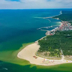 Widok z lotu ptaka na Hel – polskie egzotyczne miejsca z piaszczystą plażą, lasem i portem.