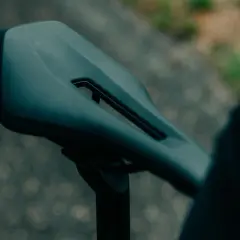 Ciemne siodełko rowerowe z wycięciem, zamocowane na sztycy. Gotowe na kolejną wyprawę.