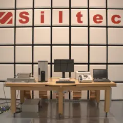 Laboratorium testowe z urządzeniami elektronicznymi i logo "Siltec". W tle ściana z paneli akustycznych, chroniąca przed zakłóceniami, jak podczas burzy (tempest).