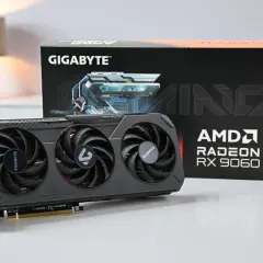 Gigabyte Gaming Grafikkarte mit AMD Radeon RX 9060 XT. Die Karte hat drei Lüfter und die Verpackung ist im Hintergrund zu sehen.