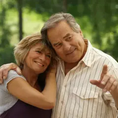 Ein glückliches älteres Paar, das sich im Freien umarmt. Sie strahlen Zufriedenheit aus, ein Beweis dafür, dass man auch im Alter liebe finden kann.