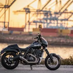 Buell super cruiser negra, lista para la aventura portuaria al atardecer.