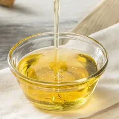 Złocisty syrop glukozowy w miseczce. Czy syrop glukozowy jest zdrowy? To pytanie nurtuje wielu konsumentów.