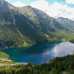 Morskie Oko, największe jezioro w Tatrach, otoczone zielonymi lasami i skalistymi szczytami.