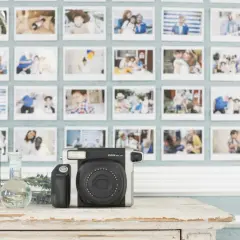 Instax aparat i ściana pełna wspomnień. To idealne miejsce, by zacząć naukę podstaw fotografii i uwieczniać ważne chwile.