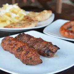 Grillowane kiełbaski i mięso mielone, klasyczne rumuńskie jedzenie, podane z frytkami i pieczywem.