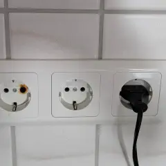 Eine Steckdose ist durchgebrannt, mit deutlichen Brandspuren im linken Anschluss. Ein Stecker ist im rechten Anschluss.