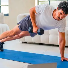 Uomo in posizione di plank con manubrio, esercizio per come migliorare la postura. Allenamento a casa.