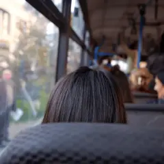 Widok z autobusu na ludzi i budynki. Codzienna podróż do pracy poza miejscem zamieszkania.